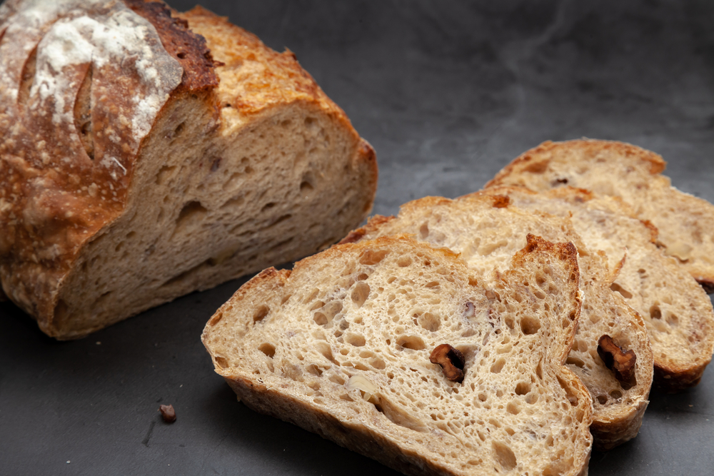 Sliced sourdough bread on dark cement background.